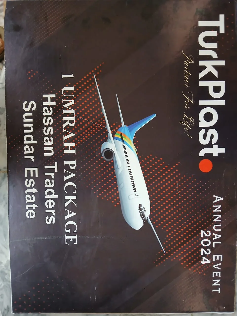 TurkPlast's award card reading 1 Umrah Package, Hassan Traders, Sundar Estate, Annual Event 2024