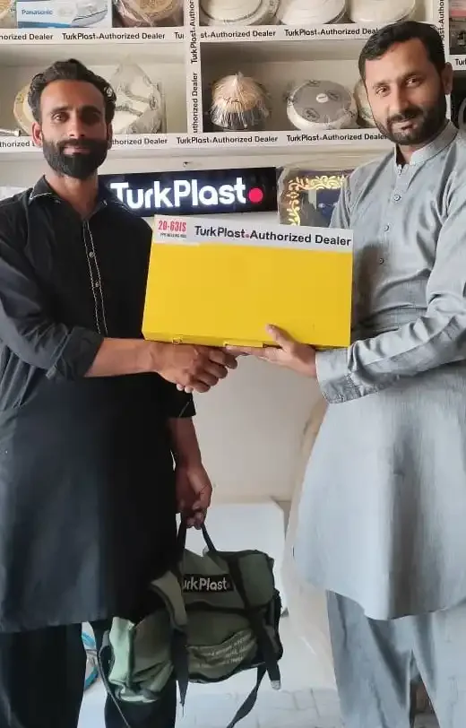 A TurkPlast kit bag and fittings handed over in front of the shop's TurkPlast Authorized Dealer shelves