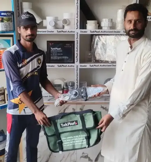 TurkPlast fittings and a kit bag handed over in front of the shop's TurkPlast Authorized Dealer shelves